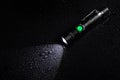 Tactical waterproof flashlight with waterdrops on black background Royalty Free Stock Photo