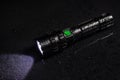 Tactical waterproof flashlight with waterdrops on black background Royalty Free Stock Photo