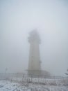 Tadiocommunication tower in fog. Klinovec Mountain