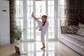 Taekwondo girl in kimono with white belt exercising at home in living room. Online education during coronavirus covid-19 lockdown Royalty Free Stock Photo