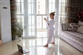 Taekwondo girl in kimono with white belt exercising at home in living room. Online education during coronavirus covid-19 lockdown Royalty Free Stock Photo