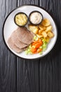 Tafelspitz is boiled beef in broth, served with a vegetables and horseradish close-up in a plate. vertical top view