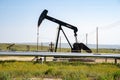 An oil derrick works in the field on a sunny day. California is one of the United States Royalty Free Stock Photo