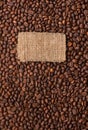 Tag made of burlap lies against the backdrop of coffee beans Royalty Free Stock Photo