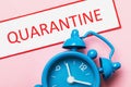 Tag with text and alarm clock on pink background. Concept of the time action of the introduced quarantine Royalty Free Stock Photo