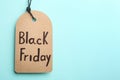 Tag with words BLACK FRIDAY on turquoise background. Space for text Royalty Free Stock Photo