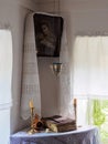 A place for prayer with an icon, an icon lamp, candles, prosphora and an old bible in the museum `Chekhov`s House`
