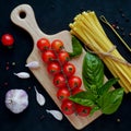 Tagliatelle with cherry tomatoes and basil on a black background