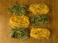 Tagliatelle or fetuccine yellow and green pasta on wooden t Royalty Free Stock Photo