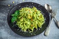 Tagliatelle pasta with pesto sauce, pine nuts and parmesan on black plate. Royalty Free Stock Photo