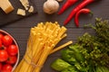 Tagliatelle pasta on the table surrounded by spicy herbs and vegetables Royalty Free Stock Photo