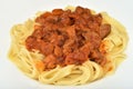 Tagliatelle pasta with tomato sauce, pork pieces, carrot slices, onion pieces and chopped parsley Royalty Free Stock Photo