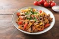 Tagliatelle with sauce from minced meat, tomatoes and vegetables in bolognese style, with parmesan and parsley on a plate and a Royalty Free Stock Photo