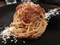 Spaghetti bolognese with parmesan.Black plate . Pasta dinner