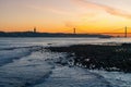 Tagus River Rio Tejo at sunset with 25 de Abril Bridge and Sanctuary of Christ the King skyline on background - Lisbon, Portugal Royalty Free Stock Photo