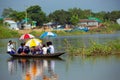 Children with school uniforms and umbrellas sitting inside the boat. School students affected by flood and going to school by boat Royalty Free Stock Photo