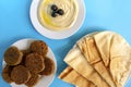 Tahina dipping, pita bread and falafel on blue background. Flat lay, top view. Egypt food Royalty Free Stock Photo