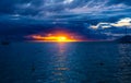 Tahiti sunset revealed behind a dramatic cloudscape, with the tranquil waters of an ocean