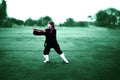 Taichi wushu master woman in the Outdoors move with the fan Royalty Free Stock Photo