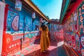 TAICHUNG,TAIWAN-NOVEMBER 30,2019:Asian female tourists visit the old house at Rainbow Village, colorful paintings on the walls in Royalty Free Stock Photo