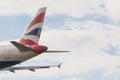 The tail of a British Airways airplane on a cloudy sky