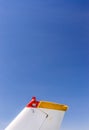 Tail fin, rudder and beacon lights, small single engine airplane with old paint and bright blue sky. Royalty Free Stock Photo