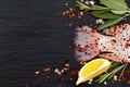 Tail of fresh raw red tilapia fish on black slate stone board with spices, herbs and pink salt. Royalty Free Stock Photo