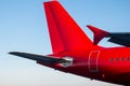 Tail and rear of the passenger airplane of red color against the blue sky Royalty Free Stock Photo