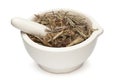 Closeup of Dry Mayurshikha leaves, in white ceramic mortar and pestle.