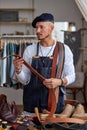 tailor in apron working with leather belt at workshop, craftsman Royalty Free Stock Photo