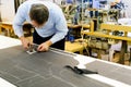 Tailor bending over a workbench cutting fabric