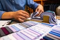 tailor choosing a fabric in swatch for his customer