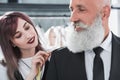 Tailor fitting smiling elderly man for suit jacket indoors Royalty Free Stock Photo