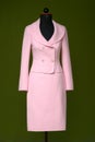 costume female suit rose pink on black tailor mannequin in front of dark green Royalty Free Stock Photo