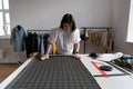 Tailor measure cloth fabric in studio. Young female designer create clothes in workshop atelier room