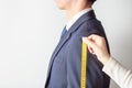 Tailor measures men`s suit, side view, white background Royalty Free Stock Photo