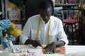 A tailor measuring fabric in his sewing shop using a measure tape. Royalty Free Stock Photo