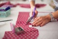 Young woman seamstress making pattern on fabric with tailors chalk. Girl working with a sewing pattern. Hobby sewing as a small bu