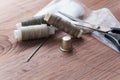 The tailor`s desk. Old sewing wooden drums or skeins on an old wooden worktable with scissors.