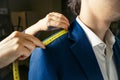 Tailor`s hands measuring men`s shoulder Royalty Free Stock Photo