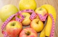 Tailor`s meter and fruit, apples, bananas, greyfruit. Chocolate or fruit diet. Choose a product for weight loss. Calorie count.
