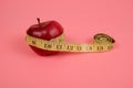 The tailor`s meter is wrapped around an apple.the concept of healthy eating.the concept of weight control Royalty Free Stock Photo