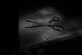 Tailor`s scissors on wooden table in low light. Artwork decoration with toned foggy backlight