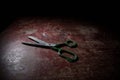 Tailor`s scissors on wooden table in low light. Artwork decoration with toned foggy backlight