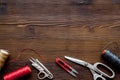 Tailor`s work desk. Thread and sciccors on dark wooden background top-down copy space Royalty Free Stock Photo