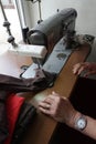 Tailor sews clothes in vintage workshop. Person sews clothes. Repairing clothes on vintage sewing machine.