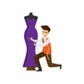 Tailor standing on one knee hemming purple dress on mannequin