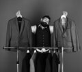 Tailor with a suit. Fashion choice concept. Man with beard by clothes rack.