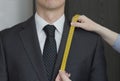 The tailor takes measurements from suit, white background, isolated