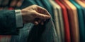 Tailor threading a needle, fabrics of various colors blurred in the background. Royalty Free Stock Photo